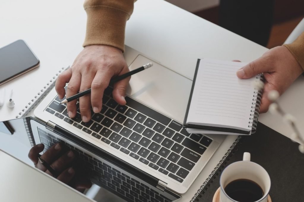 male with notepad and laptop