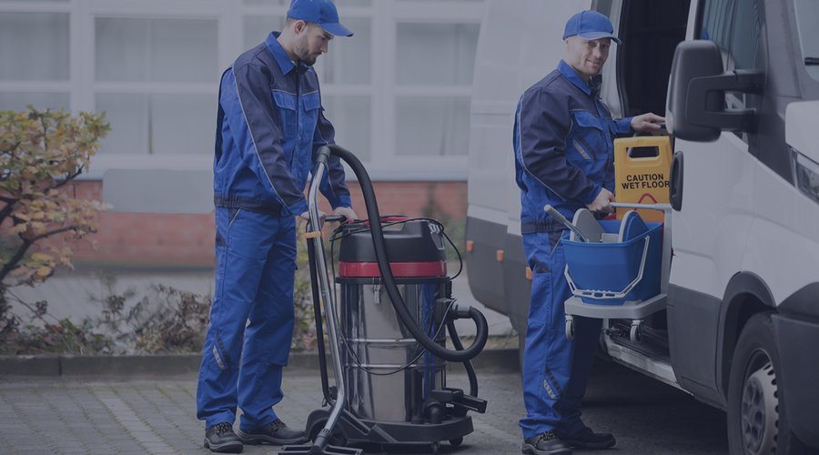 Two men outside truck with cleaning machine