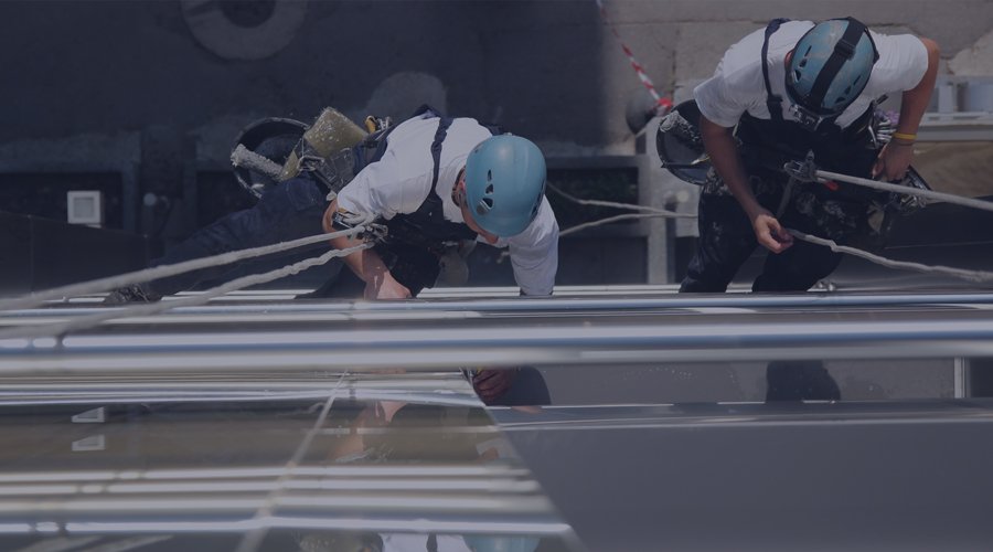 Men working on the side of tall building