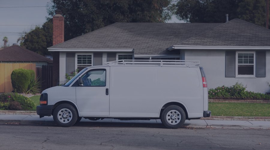 Van parked outside of a house on a residential street.