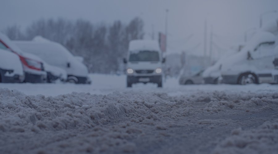 Van driving in snowy parking lot