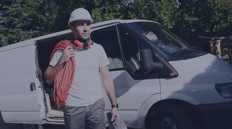 Electrician walking in front of van with open door