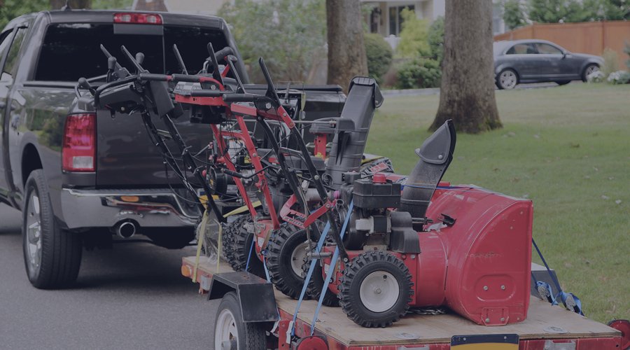 Truck parked on a street hauling different lawnmowers 